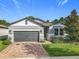 Beautiful one-story home featuring a brick driveway, gray paint, and stone veneer accents at 2247 Marsh Sedge Ln, Winter Park, FL 32792