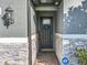 Charming front entryway with a modern door, stone accents, and an ADT security system at 2247 Marsh Sedge Ln, Winter Park, FL 32792