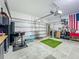 Functional garage featuring storage, a workbench, golf simulator mat, and access to garage door mechanics at 2247 Marsh Sedge Ln, Winter Park, FL 32792