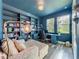 Stylish blue home office with custom built-ins, comfortable seating, and ample natural light at 2247 Marsh Sedge Ln, Winter Park, FL 32792