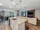 Open-concept kitchen with a large island, seating, and a view into the living room and dining area at 2247 Marsh Sedge Ln, Winter Park, FL 32792