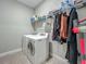 Efficient laundry room with washer, dryer, shelving, and storage rack for a clean and organized space at 2247 Marsh Sedge Ln, Winter Park, FL 32792