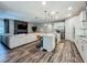 Open-concept living room features an island kitchen, stone fireplace, and a comfortable sectional sofa at 2247 Marsh Sedge Ln, Winter Park, FL 32792