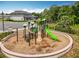 Community playground with climbing structures and a slide set amongst mature landscaping at 2247 Marsh Sedge Ln, Winter Park, FL 32792