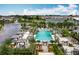 A beautiful community pool with seating and cabanas, set beside a pond with a fountain feature at 2247 Marsh Sedge Ln, Winter Park, FL 32792