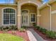 Charming front entry with a white door, beautiful landscaping, and brick walkway at 2274 Foliage Oak Ter, Oviedo, FL 32766