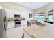 The kitchen has white cabinets, stainless appliances, generous counters, and lots of natural light at 2274 Foliage Oak Ter, Oviedo, FL 32766