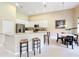 Bright kitchen features white cabinetry, stainless steel appliances, breakfast bar, and adjacent dining area at 2274 Foliage Oak Ter, Oviedo, FL 32766