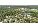 Expansive aerial view of the neighborhood with lush greenery, a school complex, and a serene lake at 2312 S Summerlin Ave, Orlando, FL 32806