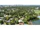 Lush aerial view of the neighborhood featuring homes, trees, a pond, and the city skyline in the distance at 2312 S Summerlin Ave, Orlando, FL 32806