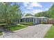 Well-maintained single-story home with a blue exterior, black shutters, and a brick-paved driveway at 2312 S Summerlin Ave, Orlando, FL 32806