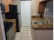 Galley kitchen with stainless steel appliances, tile floor, and wood cabinets at 236 Afton Sq # 207, Altamonte Springs, FL 32714