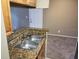 Open kitchen with granite countertops, stainless steel sink, and a view into the living area at 236 Afton Sq # 207, Altamonte Springs, FL 32714