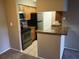 Galley kitchen with stainless steel appliances, granite counters, and wood cabinets at 236 Afton Sq # 207, Altamonte Springs, FL 32714