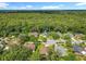 An aerial view displays houses nestled amidst lush tree cover, highlighting the tranquil community and natural surroundings at 2489 Tommys Turn, Oviedo, FL 32766