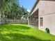 Exterior view of the lush backyard featuring a well-maintained lawn and a screened-in porch connected to the house at 2489 Tommys Turn, Oviedo, FL 32766