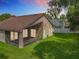 Exterior backyard view featuring the home, screened-in patio, and an expansive green lawn at 2489 Tommys Turn, Oviedo, FL 32766