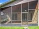 This is an exterior view of the screened-in lanai from the grassy backyard, featuring tile flooring at 2489 Tommys Turn, Oviedo, FL 32766