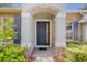 Inviting front entrance featuring a brick-arched porch and a stylish, dark blue front door at 2782 Cedar Knoll Dr, Apopka, FL 32712