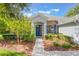 Inviting front entrance with a blue door, stone accents, and lush landscaping, creating a welcoming curb appeal at 2782 Cedar Knoll Dr, Apopka, FL 32712