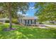 Charming home with well-maintained lawn, blue shutters, stone accents, and mature trees at 2782 Cedar Knoll Dr, Apopka, FL 32712