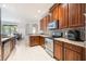 Well-lit kitchen with stainless steel appliances, tiled floors, granite countertops, and beautiful wood cabinetry at 2782 Cedar Knoll Dr, Apopka, FL 32712