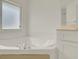 Spacious bathtub in a well-lit bathroom with white tile and frosted window, perfect for relaxation and privacy at 295 Maguire St, Deltona, FL 32725