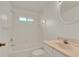 Clean bathroom featuring white tile, a tub and shower combination, and a marble-top vanity, creating a functional space at 295 Maguire St, Deltona, FL 32725