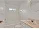 Clean bathroom featuring white tile, a tub and shower combination, and a marble-top vanity, creating a functional space at 295 Maguire St, Deltona, FL 32725
