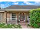 Charming brick home featuring a red front door with decorative glass and white shutters, enhancing its curb appeal at 295 Maguire St, Deltona, FL 32725