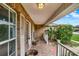 Inviting front porch with brick flooring, white railings, and lush landscaping, perfect for relaxing outdoors at 295 Maguire St, Deltona, FL 32725