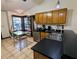 This sunlit kitchen has a stainless steel sink, black counters and light wooden cabinets at 3021 Norvell Ct, Deltona, FL 32738