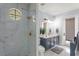 Beautiful bathroom with marble-look shower, circular window, and a stylish blue vanity at 3426 Cocard Ct, Windermere, FL 34786