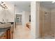 Bathroom with travertine tile, stone vessel sink, large shower, and vanity, illuminated by stylish lighting at 3426 Cocard Ct, Windermere, FL 34786