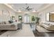 Primary bedroom with tray ceilings, lots of natural light, and a seating area with a curved sofa at 3426 Cocard Ct, Windermere, FL 34786