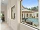 View of the pool area through the hallway window showcasing an outdoor table and lounge chairs at 3426 Cocard Ct, Windermere, FL 34786