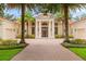 Elegant single-story home featuring a brick driveway, columns, and lush landscaping with palm trees at 3426 Cocard Ct, Windermere, FL 34786