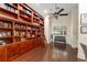 Library showcasing a large, custom wooden bookshelf with a rolling ladder and hardwood floors at 3426 Cocard Ct, Windermere, FL 34786