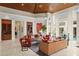 Open-concept living room with high wood ceilings, multiple seating areas, and views of the backyard and pool at 3426 Cocard Ct, Windermere, FL 34786