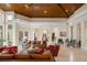 Large living room with wood ceilings, stone floors, multiple seating arrangements, and access to the backyard at 3426 Cocard Ct, Windermere, FL 34786