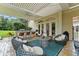 Spacious covered patio with an outdoor kitchen, bar seating, and cozy lounge furniture at 3426 Cocard Ct, Windermere, FL 34786