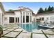 Beautiful backyard pool featuring travertine decking, manicured lawn, splash pad, and fountains at 3426 Cocard Ct, Windermere, FL 34786