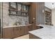 Beautiful wet bar with custom cabinets, stone backsplash, marble counters, a wine rack, and decorative elements at 3426 Cocard Ct, Windermere, FL 34786