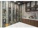 A stylish home bar with wine racks, custom cabinetry, a marble countertop, and a view of the wine cellar at 3426 Cocard Ct, Windermere, FL 34786