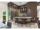 Unique wine room with custom glass enclosure, temperature control, and stylish bar area with seating at 3426 Cocard Ct, Windermere, FL 34786
