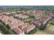 Aerial view showcasing the community's terracotta roofs, lush greenery, and a serene lake at 3508 Porta Romano Way, Lake Mary, FL 32746