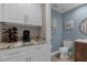 Stylish powder room with granite counters, white cabinets, and blue accent walls at 3508 Porta Romano Way, Lake Mary, FL 32746