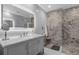 Sleek bathroom with marble tile, double vanity, frameless shower, and contemporary lighting, creating a spa-like retreat at 3508 Porta Romano Way, Lake Mary, FL 32746