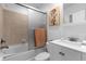 Bathroom with tiled shower over tub, white vanity, and neutral color scheme, creating a clean and functional space at 3508 Porta Romano Way, Lake Mary, FL 32746