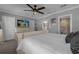 Bright bedroom featuring plush white bedding, modern ceiling fan, light walls, and an en-suite bathroom entrance at 3508 Porta Romano Way, Lake Mary, FL 32746